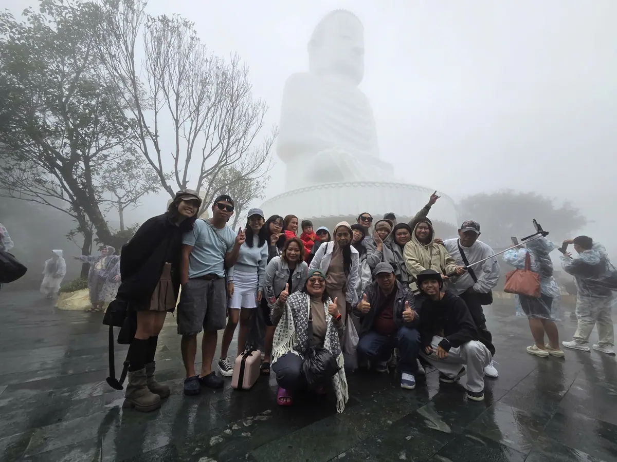 Our guests at Linh Ung Pagoda in Da Nang on a wet-season day — the Lady Buddha statue is in the cloud behind them